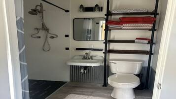 Een douche, handdoeken, zeep, toiletpapier