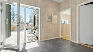 Un intérieur moderne avec une porte-fenêtre coulissante donnant sur un patio extérieur.
