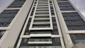 Un edificio de gran altura con un diseño arquitectónico moderno, que presenta múltiples balcones y ventanas amplias.