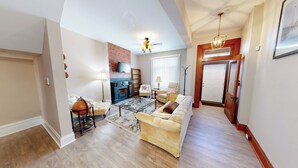 A spacious living room with a fireplace, a large sofa, a coffee table, and a globe. - ENTIRE Big Family Home Close To Zoo and Events - Private Patio and Firepit (Pittsburgh)