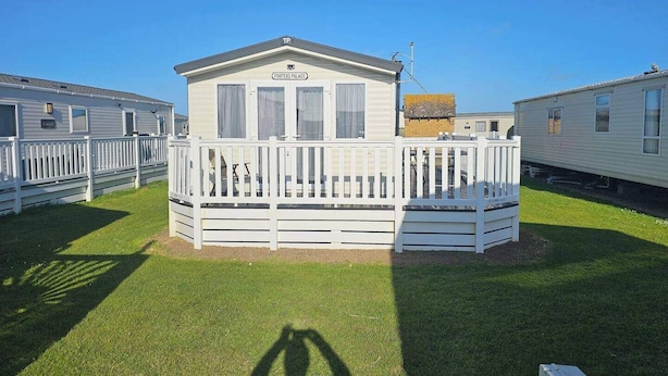 Una casa mobile con una veranda recintata e un piccolo portico, con la scritta 'Porters Palace'.