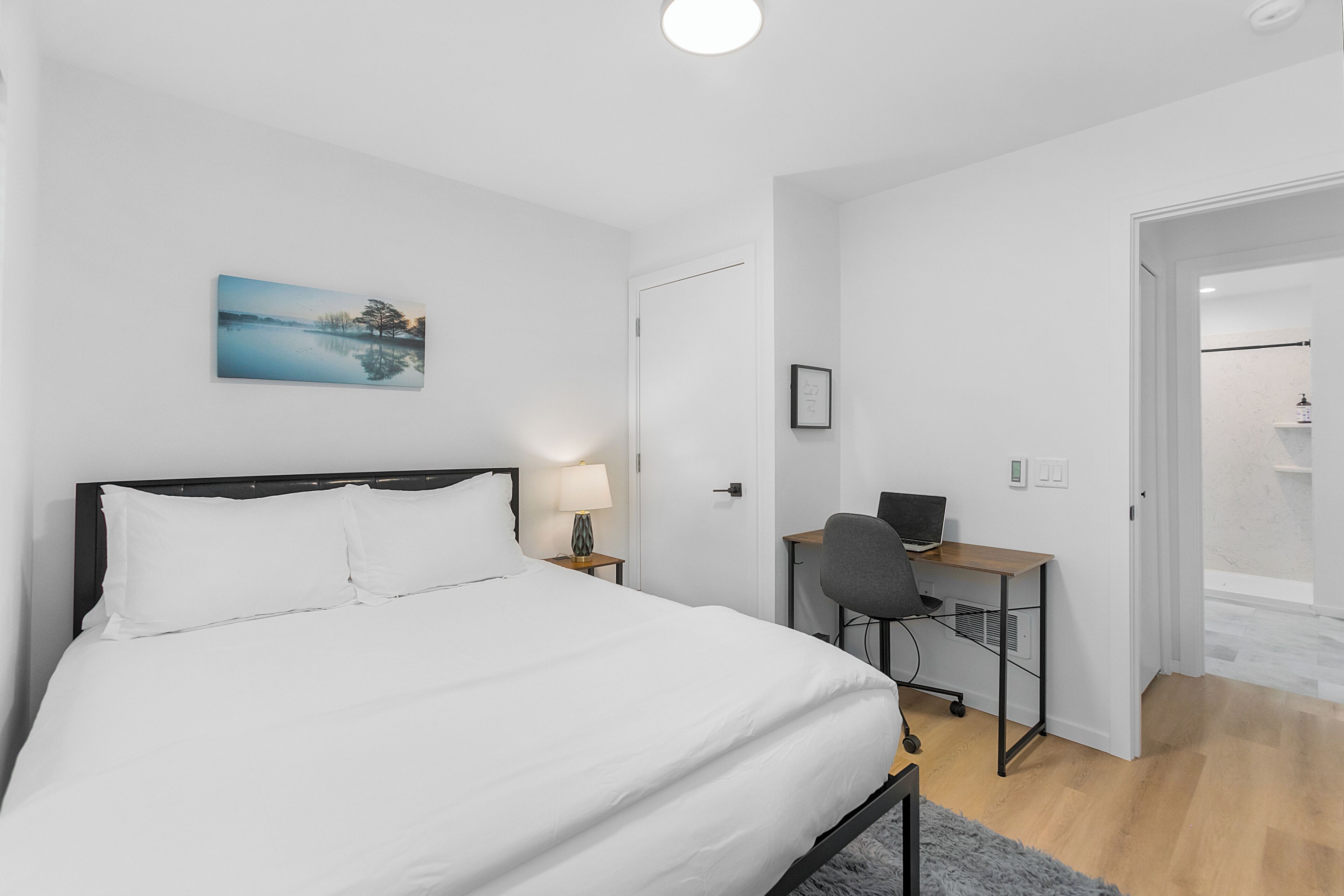 Ein Schlafzimmer mit einem Bett, einem Schreibtisch und einem Sessel.