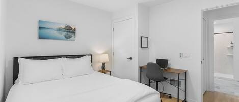 Ein Schlafzimmer mit einem Bett, einem Schreibtisch und einem Sessel.