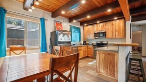 Una cocina con armarios de madera, un refrigerador y un microondas.
