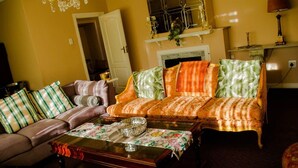 A cozy living room with a sofa set, a coffee table, and a fireplace. - The Advocate Suites Manor (Maseru)