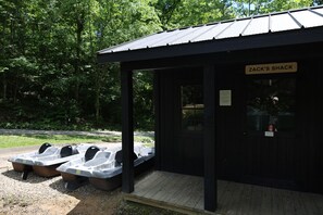 A wooden structure labeled 'ZACK'S SHACK' with a covered seating area and two boats outside.