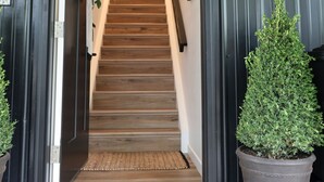A wooden staircase leading to a room with a sign reading 'The Hayloft.' - Creative Cabins - Hayloft (Logan)