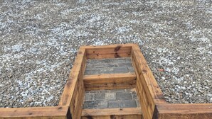 Een houten trap die naar een stenen plateau leidt.