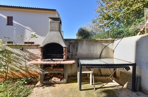 Enjoy a rustic outdoor cooking experience with a traditional wood-fired oven and seating area.