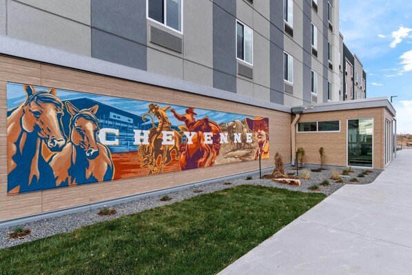 A building exterior with a mural of horses and the word "CHEYENNE" prominently displayed.