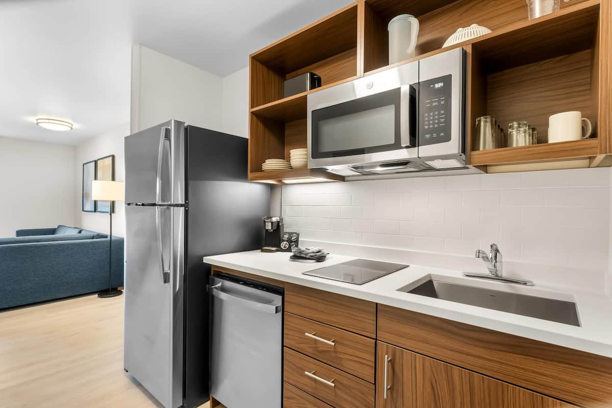 A modern kitchen with a stainless steel refrigerator, microwave, and dishwasher.