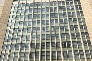 Un edificio moderno de gran altura con una fachada y ventanas dispuestas en cuadrícula.
