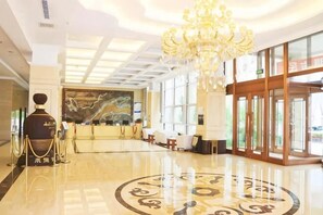 A hotel lobby with a chandelier, reception desk, and large windows. - Lidu Hotel (Weichang)