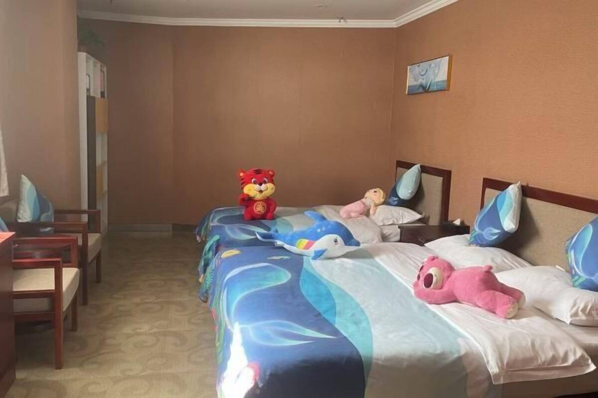 Ein Hotelzimmer mit zwei Betten, auf jedem Kopfkissen ein anderes Plüschtier.