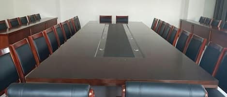 A conference room with a long table and chairs, a projector, and a whiteboard.