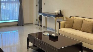 Una sala de estar moderna con un sofá, una mesa de centro, un escritorio y una ventana con cortinas.