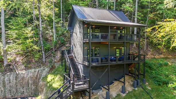 Eine mehrstöckige Holzhütte mit Metallbedachung, umgeben von dichtem Wald.