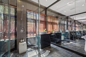 A modern bathroom with a glass shower enclosure, a white pedestal sink, and a large mirror. - Villa Skyfall : Spectacular 8 Bedroom Pool Villa with Private Cinema (Koh Samui)