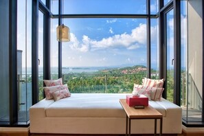 A room with a large window, a sofa, and a small table. - Villa Skyfall : Spectacular 8 Bedroom Pool Villa with Private Cinema (Koh Samui)