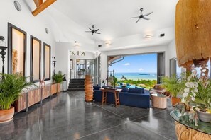 Eine geräumige Lobby mit Meerblick, einer Treppe und einer Sitzecke mit Pflanzen.