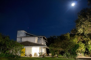 Una casa con un ampio portico, un garage visibile e un prato curato.