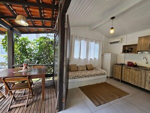 Cocina compacta con comedor, sofá y vistas al exterior.