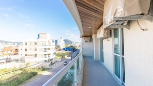 A balcony with a view of a cityscape, a tiled floor, and a railing. - 150m do Mar! Cobertura Duplex com Piscina Privada (Bombinhas)