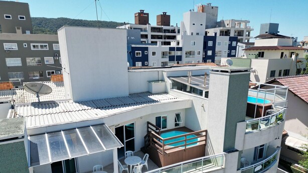 A modern multi-story building with a rooftop pool, outdoor seating, and a satellite dish. - 150m do Mar! Cobertura Duplex com Piscina Privada (Bombinhas)