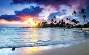 A beach with palm trees and a sunset. - 5 Beds Downstairs Corner Unit with AC, 3 Pools, 6 minutes to Beaches, Beach Cart (Koloa)