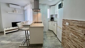 A compact kitchen with a central island, a built-in microwave, and a coffee maker. - Vacation Apartment 'Relaxing Los Cristianos' with Sea View, Wi-Fi and Air Conditioning (Los Cristianos)