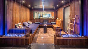 Un interior moderno con una zona de estar, paneles de madera y vistas por una ventana.