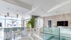 Una cocina moderna con taburetes de bar, una isla grande y un separador de vidrio.