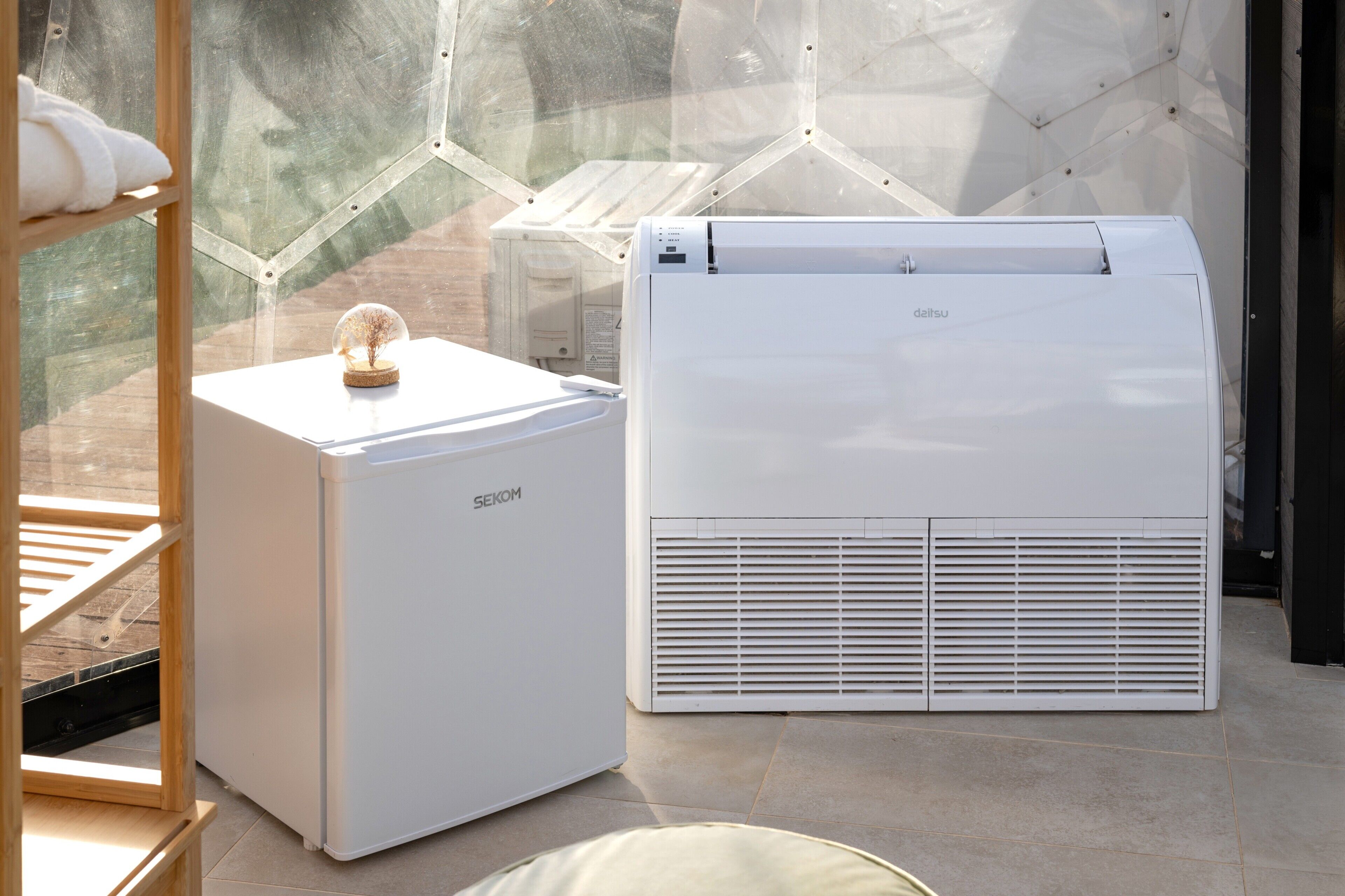 Eine moderne Klimaanlage und ein gläserner Raum mit einem Holzregal und einem dekorativen Gegenstand.