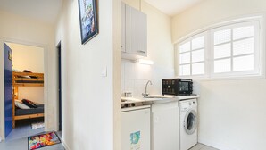 A compact kitchen with a washing machine, a microwave, and a sink.