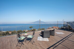 A terrace with a view of the sea and a mountain, furnished with chairs and a table. - Holiday Home 'Camera Ulivo Con Vista Mare' with Sea View, Wi-Fi and Air Conditioning (Montechiaro - Vico Equense)