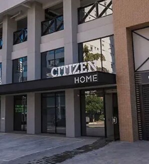 A building with a sign that reads 'CITIZEN HOME'. - Loft Amplo e Moderno no Bueno (Goiânia)