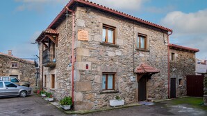 A stone building with a balcony, a small window, and a door.