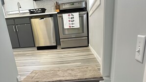 Portaat johtavat keittiöön, jossa on ruostumattomasta teräksestä valmistettu jääkaappi ja uuni.