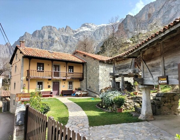 A two-story building with a balcony, stone pathway, and a sign indicating 'El Jermoso.'