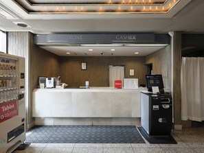 A hotel reception desk with a cash register, a vending machine, and a sign for a Tabist coffee machine. - Tabist THE GREEN SAPPORO (Sapporo)