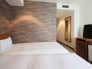 Une chambre d’hôtel avec un lit, un mur en bois, un miroir, une télévision et une petite armoire.