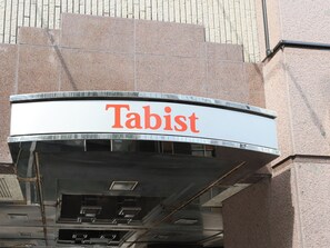 A building with a curved sign that reads 'Tabist.' - Tabist THE GREEN SAPPORO (Sapporo)