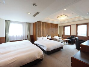 A hotel room with two beds, a desk, a chair, and a large window. - Tabist THE GREEN SAPPORO (Sapporo)