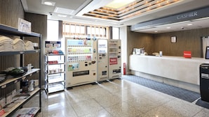 A modern hotel lobby with vending machines, a cash register, and a reception desk. - Tabist THE GREEN SAPPORO (Sapporo)