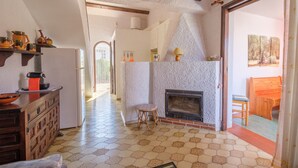 A kitchen with a fireplace, wooden cabinets, and a tiled floor. - Holiday Home “Vistamar 2” with Sea View, Terrace and Wi-Fi (Vinarós)
