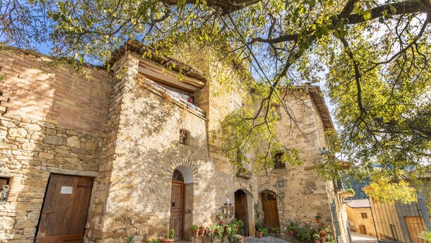 Un edificio de piedra con arcos y un patio adoquinado.