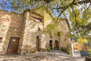 Un bâtiment en pierre, doté d’arcades et d’une cour pavée.