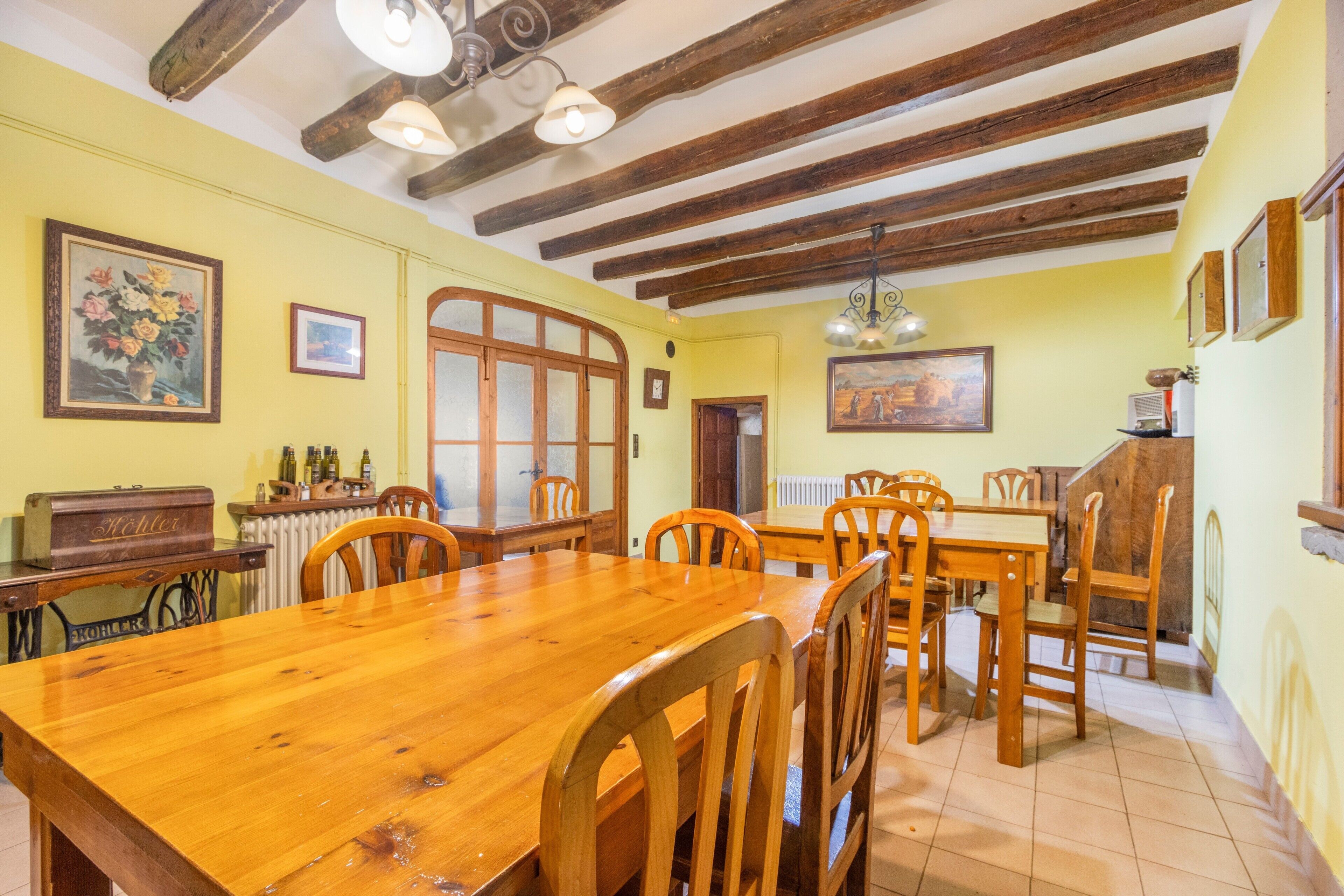 Un coin repas avec des meubles en bois, un radiateur et un plafond en bois.
