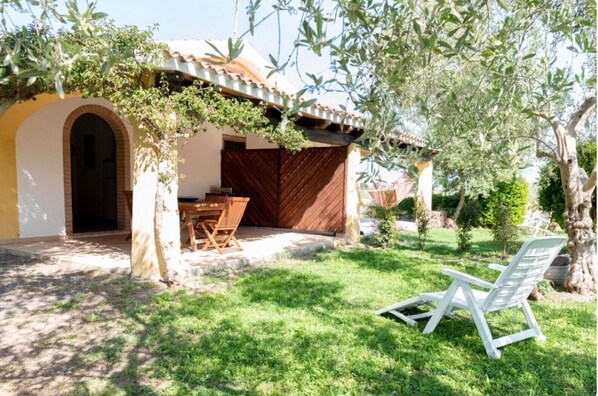 Una villa con patio, zona pranzo e una sedia bianca.