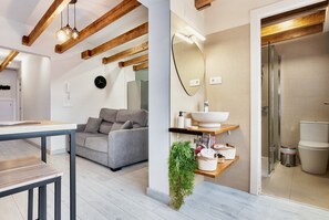 A modern bathroom with a large mirror, a sink, and a shower.